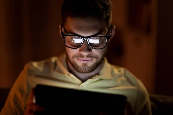 Młody człowiek z tabletem sieci w nocy — Zdjęcie stockowe