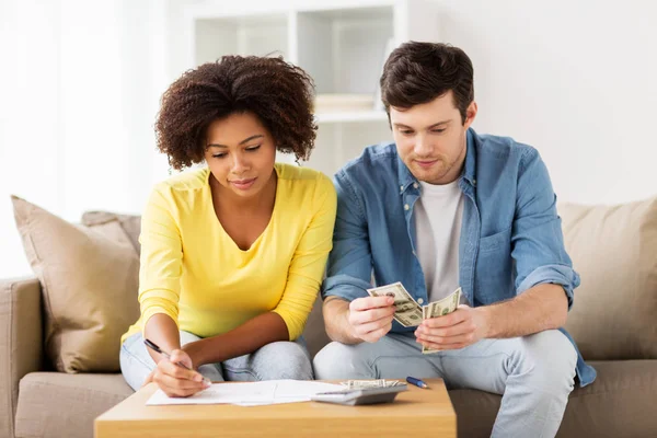 Couple avec papiers et calculatrice à la maison — Photo