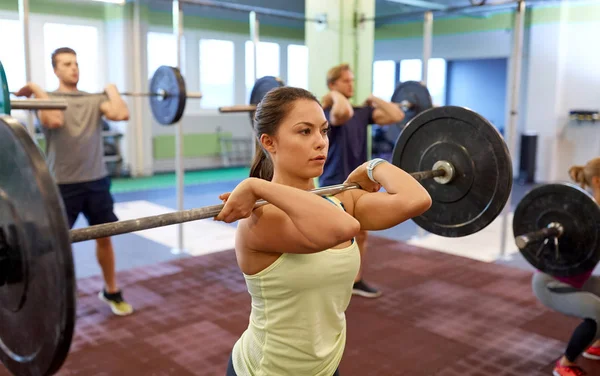 Group of people training with barbells in gym — Stock Photo, Image
