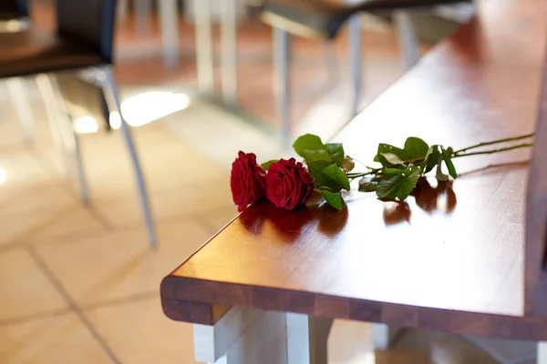 Червоні троянди на лавці на похороні в церкві — стокове фото