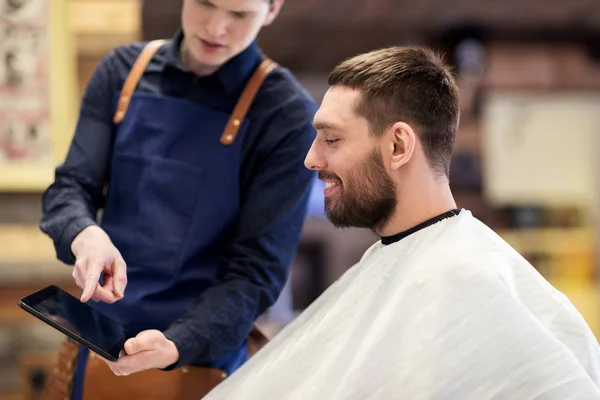 Barbiere mostrando tablet pc all'uomo al barbiere — Foto Stock