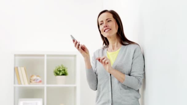 Femme heureuse appelant sur smartphone à la maison — Video