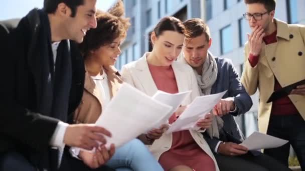 Equipe de negócios internacional com papéis ao ar livre — Vídeo de Stock