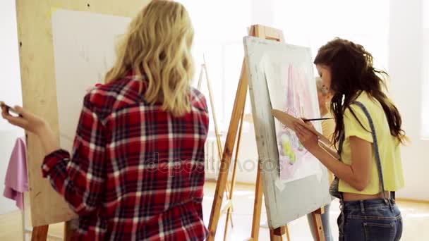 イーゼルの美術学校で絵画を持つ学生 — ストック動画