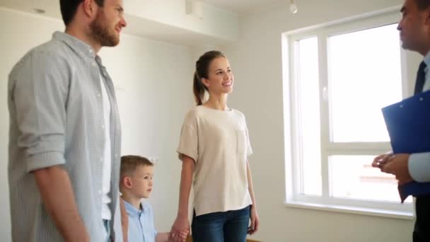 Familia feliz y agente inmobiliario en la nueva casa o apartamento — Vídeo de stock