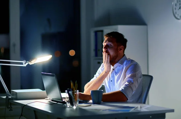 Homem com laptop e café trabalhando no escritório da noite — Fotografia de Stock