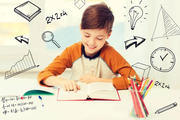 Sorridente, studente ragazzo lettura libro a casa — Foto Stock