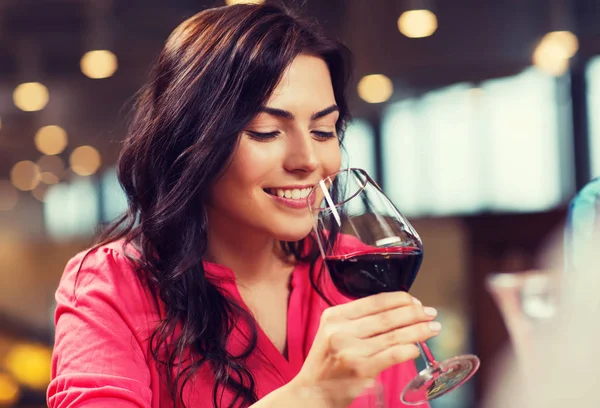 Smiling woman drinking red wine at restaurant — Stock Photo, Image
