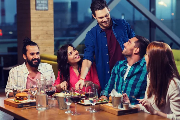 Vrienden dineren en wijn drinken in restaurant — Stockfoto