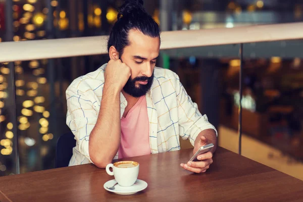 Uomo con smartphone e caffè al ristorante — Foto Stock