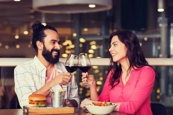 Счастливая пара ужинает и пьет вино в ресторане — стоковое фото