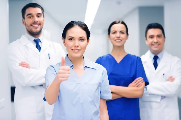 Médicos ou médicos no hospital mostrando polegares para cima — Fotografia de Stock