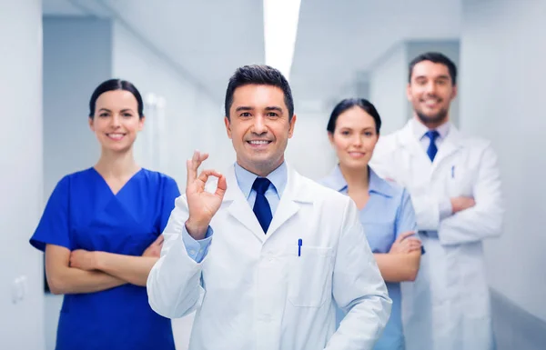 Gruppo di medici in ospedale mostrando segno mano ok — Foto Stock