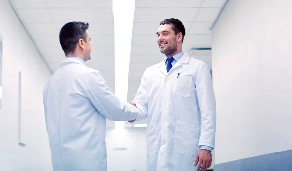 Médecins souriants à l'hôpital faisant poignée de main — Photo