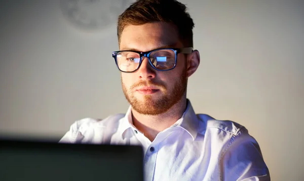 Zakenman in bril met laptop bij nacht kantoor Rechtenvrije Stockfoto's