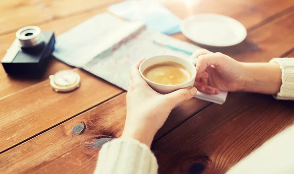 Primer plano de las manos con taza de café y cosas de viaje — Foto de Stock