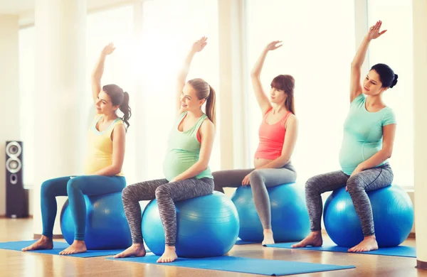 Mujeres embarazadas felices haciendo ejercicio en fitball en el gimnasio — Foto de Stock