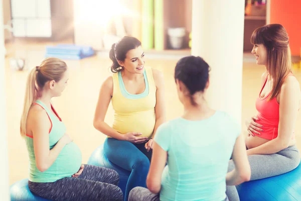 Mulheres grávidas felizes sentadas em bolas no ginásio — Fotografia de Stock