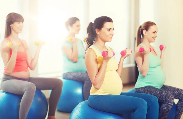 Mujeres embarazadas felices haciendo ejercicio en fitball en el gimnasio —  Fotos de Stock