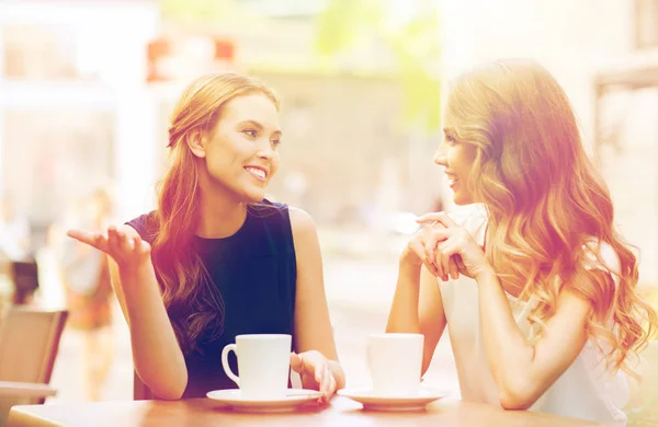 Mladé ženy, pití kávy a mluví v kavárně — Stock fotografie