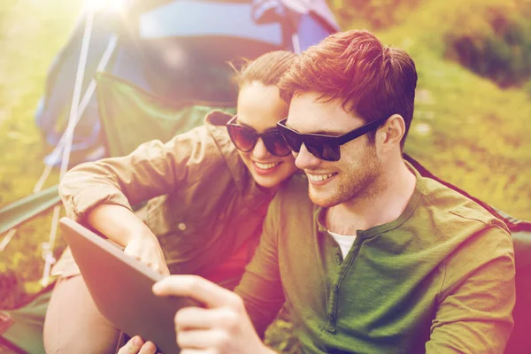 Casal feliz com tablet pc na barraca de acampamento — Fotografia de Stock