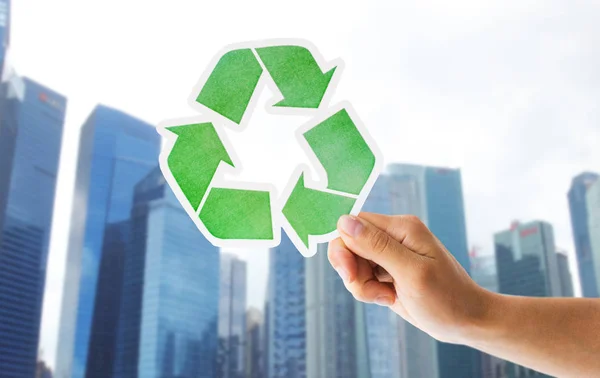 Primer plano de la mano con el cartel de reciclaje verde en la ciudad — Foto de Stock