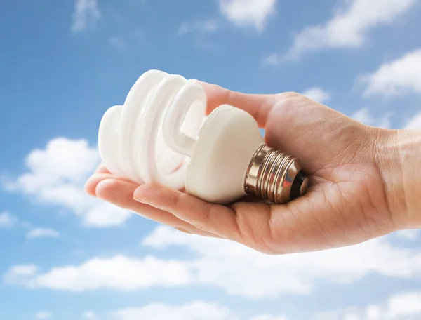 Primer plano de la mano sosteniendo bombilla de ahorro de energía — Foto de Stock