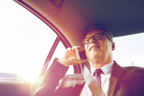 Старший бизнесмен звонит на смартфон в машине — стоковое фото