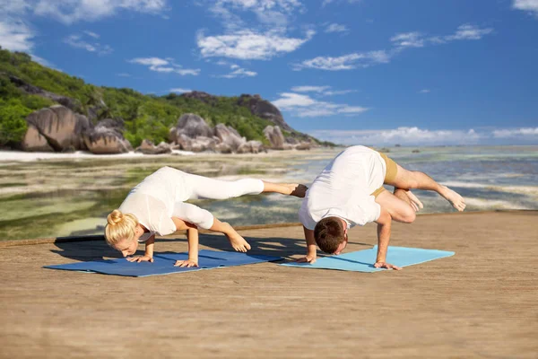 Pareja haciendo yoga lado grúa pose al aire libre — Foto de Stock