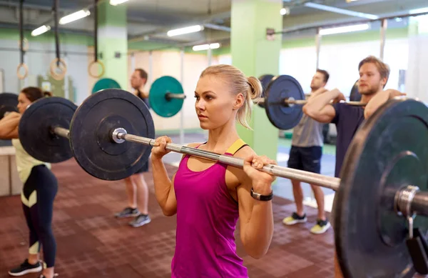 Groep mensen trainen met halters in de sportschool — Stockfoto