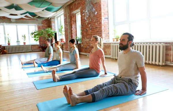 Groep mensen doen yoga personeel poseren in de studio — Stockfoto