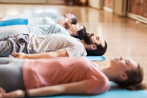 Grupo de pessoas fazendo exercícios de ioga no estúdio — Fotografia de Stock