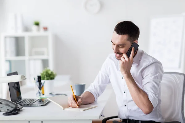 Hombre de negocios llamando en teléfono inteligente en la oficina — Foto de Stock