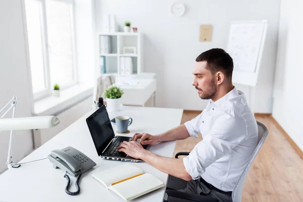 Zakenman typen op laptop op kantoor — Stockfoto