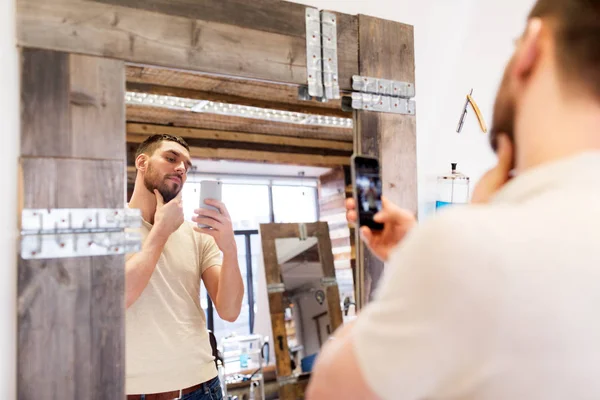 Muž vezme selfie pomocí smartphone v holičství — Stock fotografie