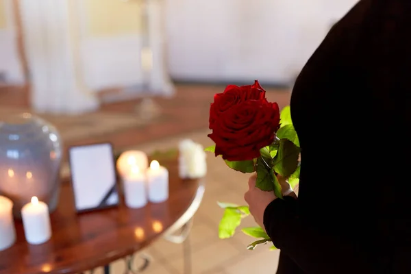 Mulher com rosas e urna cremação no funeral — Fotografia de Stock