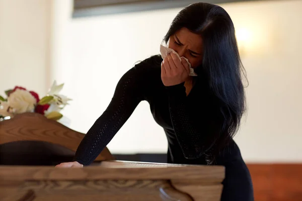 Mulher com caixão chorando no funeral na igreja — Fotografia de Stock