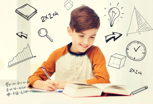 Sorridente studente ragazzo scrivendo per notebook a casa — Foto Stock