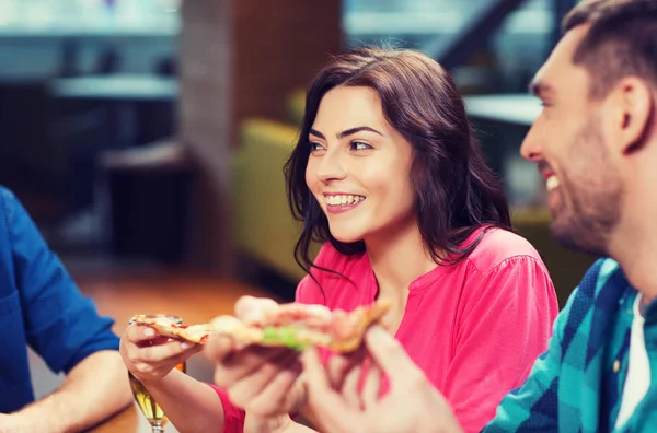 Amigos comendo pizza com cerveja no restaurante — Fotografia de Stock