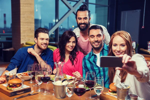 Vrienden nemen selfie door smartphone bij restaurant — Stockfoto