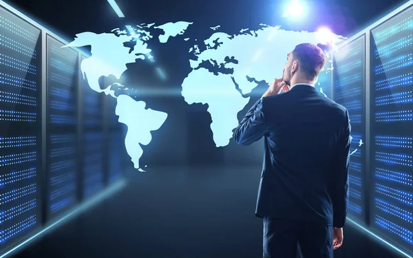 Businessman with world map projection in corridor — Stock Photo, Image