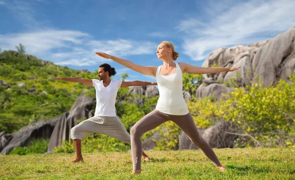 Paar macht Yoga in Kriegerpose am Meer — Stockfoto