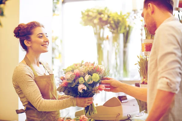 Усміхнена квіткова жінка і чоловік у квітковому магазині — стокове фото