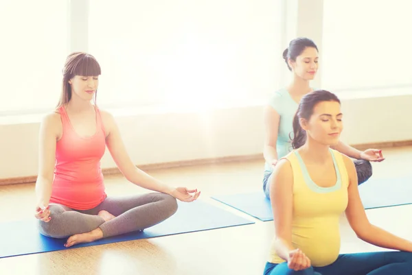 Mujeres embarazadas felices ejercitando yoga en el gimnasio Fotos de stock libres de derechos