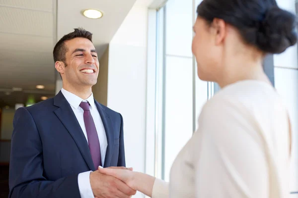 Glimlachende zakenmensen schudden handen op kantoor — Stockfoto