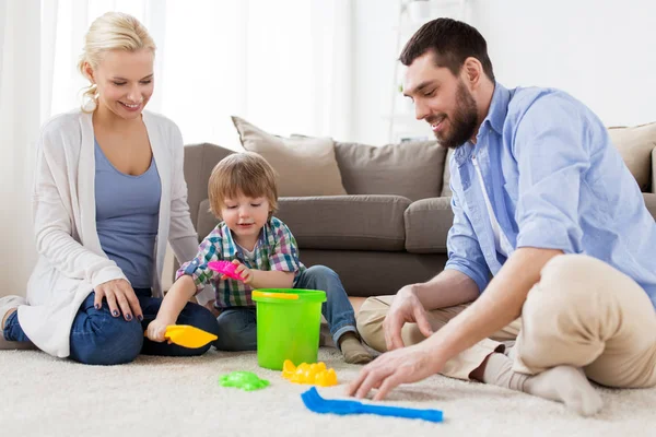 Família feliz brincando com brinquedos de praia em casa — Fotografia de Stock