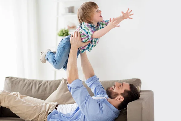 Feliz padre joven jugando con su pequeño hijo en casa —  Fotos de Stock