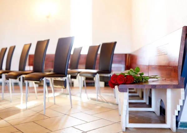 Rosas vermelhas no banco no funeral na igreja — Fotografia de Stock