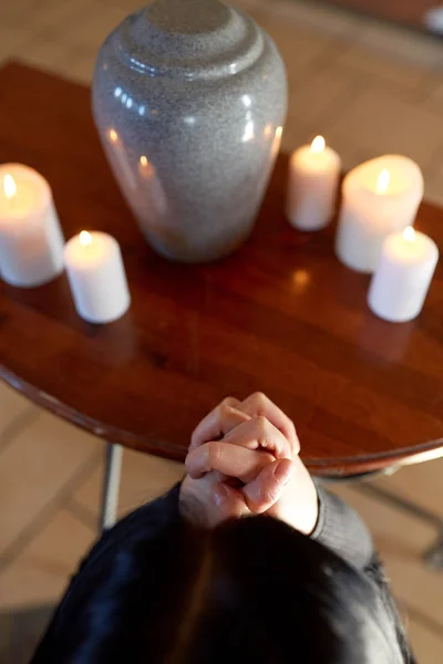 Sorgliga kvinna med begravningsurnor urn be i kyrkan — Stockfoto