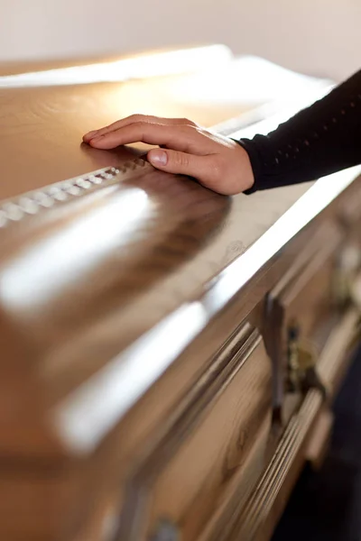 Kvinna hand på kistan locket på begravning i kyrka — Stockfoto